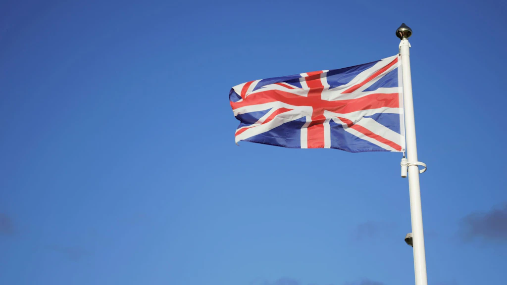 Flag of the United Kingdom against a blue sky.