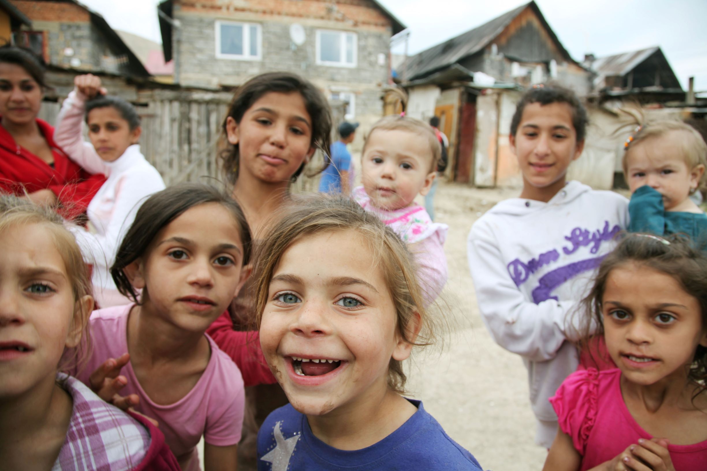 Kinder stehen vor einer Siedlung.