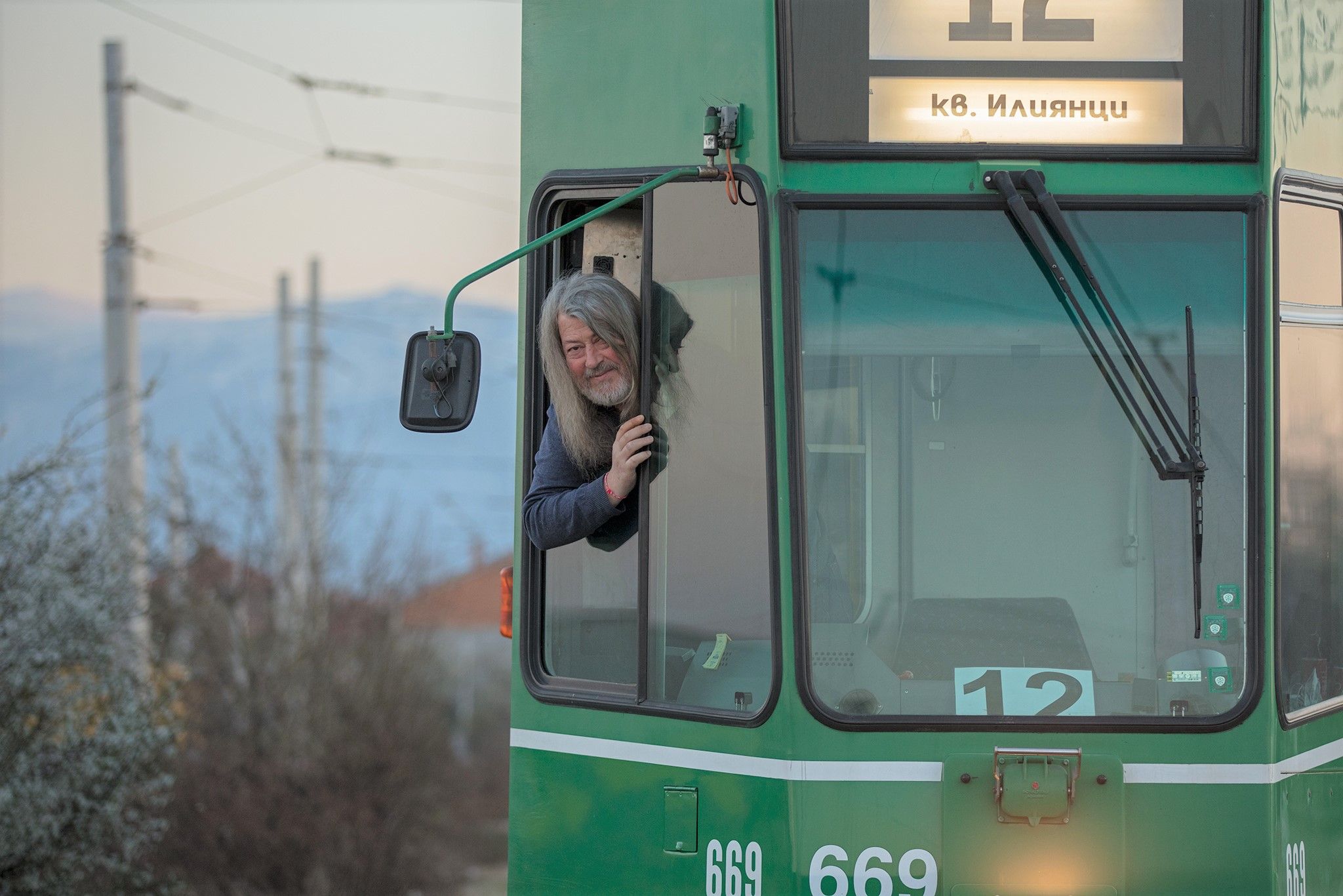 Ein Tramchauffeur steckt seinen Kopf aus dem grünen Tram.