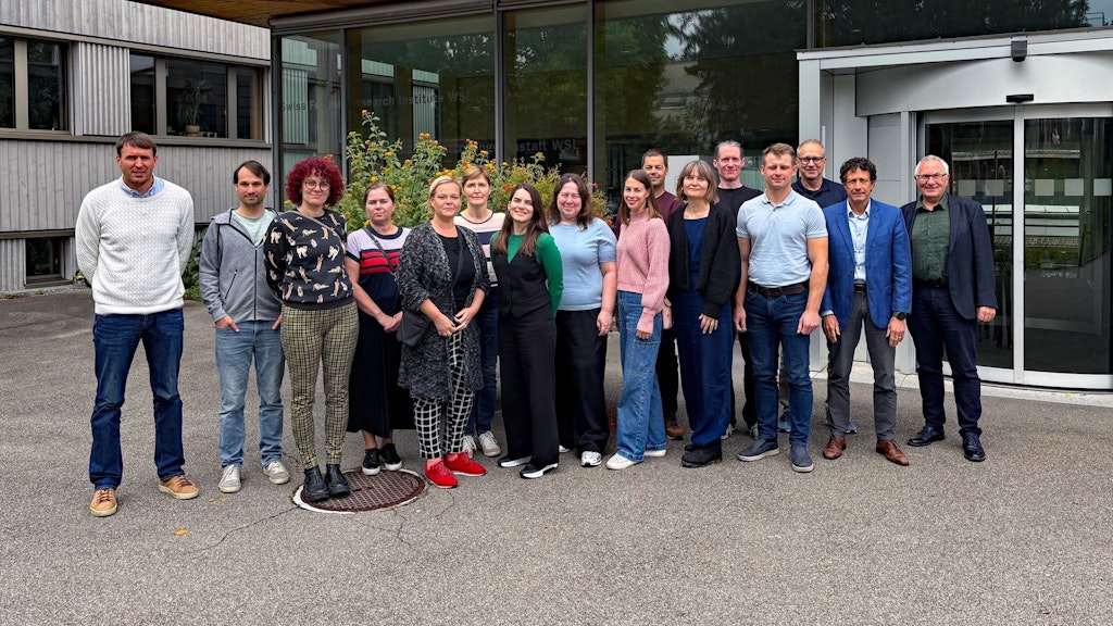 Eine Menschengruppe, die vor einem Gebäude steht.