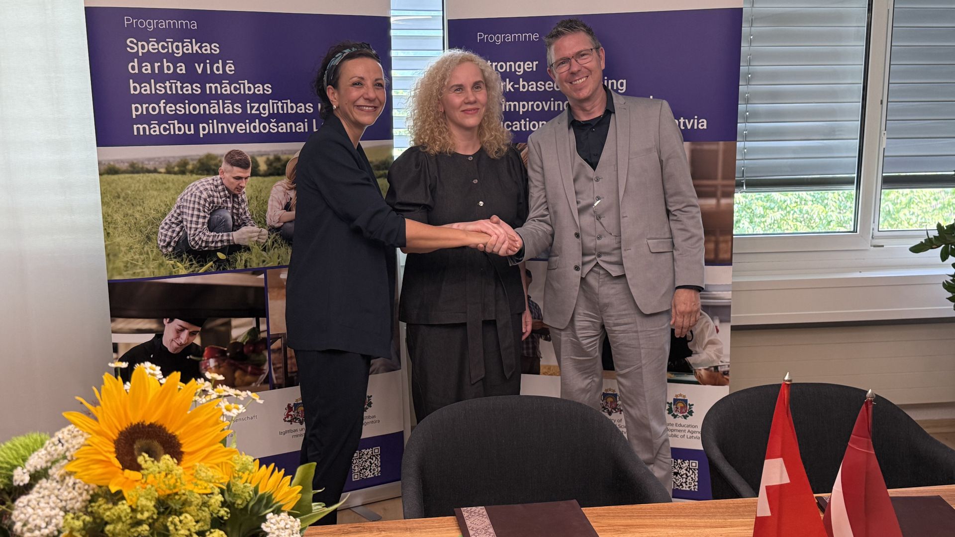 Representatives of HGf Switzerland and the Latvian national education development agency SEDA shake hands after signing the agreement.
