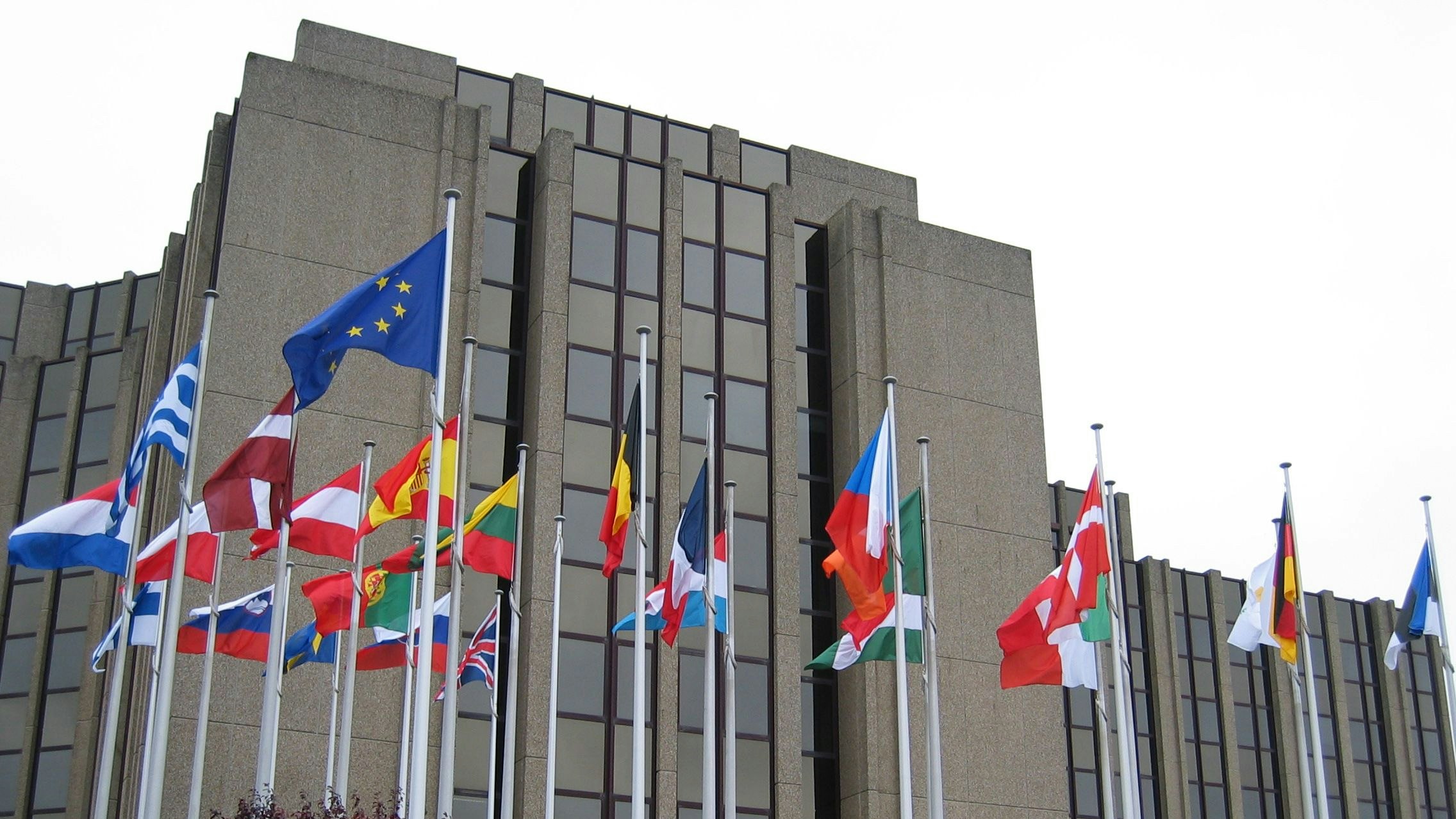 Flags of the EU member states flutter in the wind outside the European Court of Auditors building in Brussels.