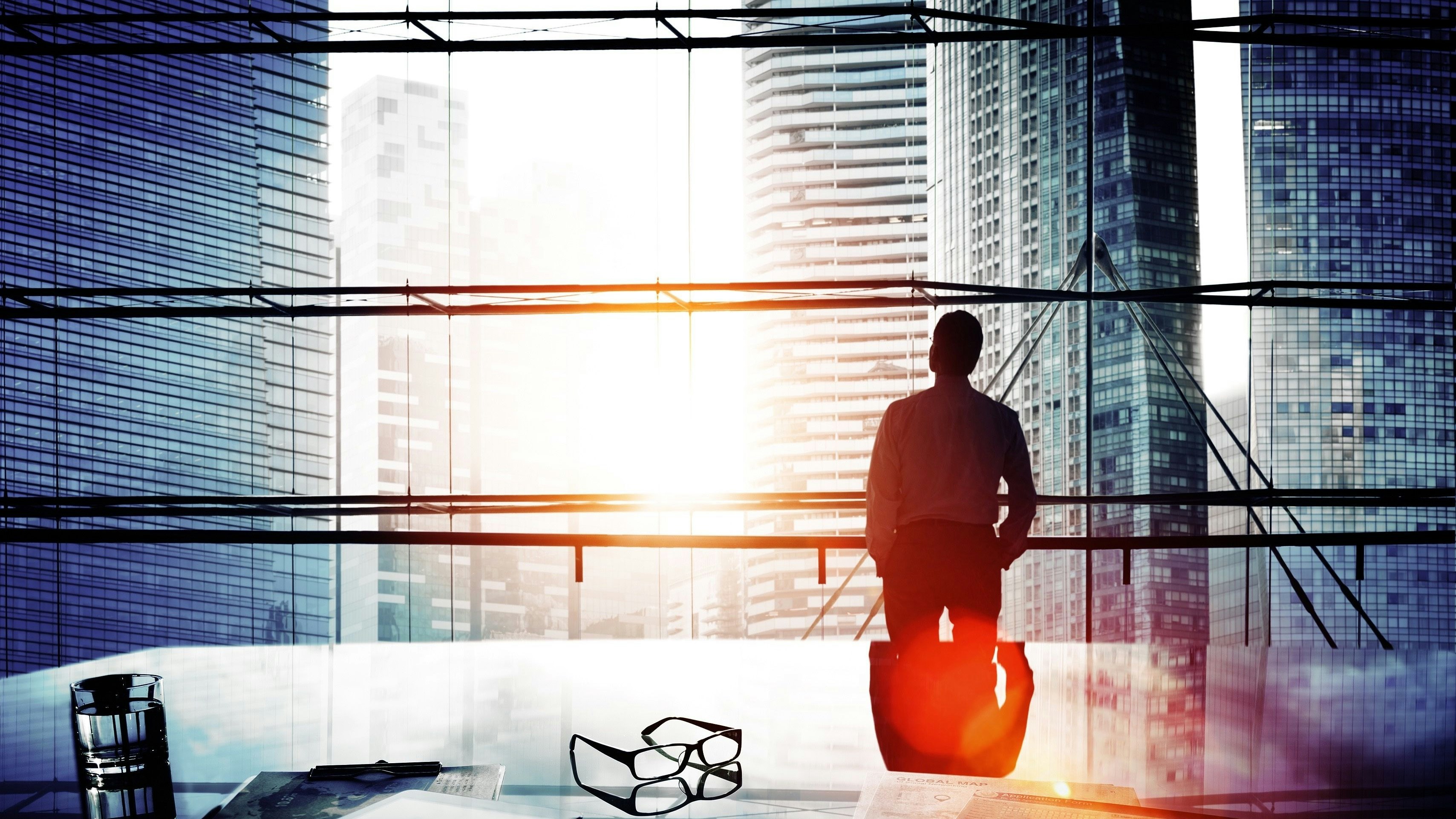 Man in skyscraper looking out of a window.