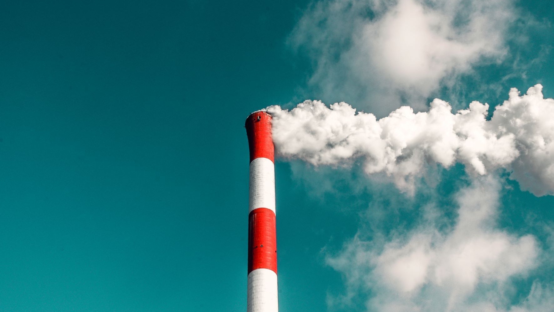 Una ciminiera industriale da cui fuoriesce il fumo.